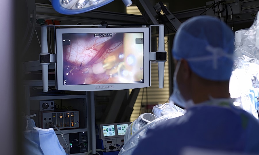 Surgeon observing procedure on monitor in operating room.