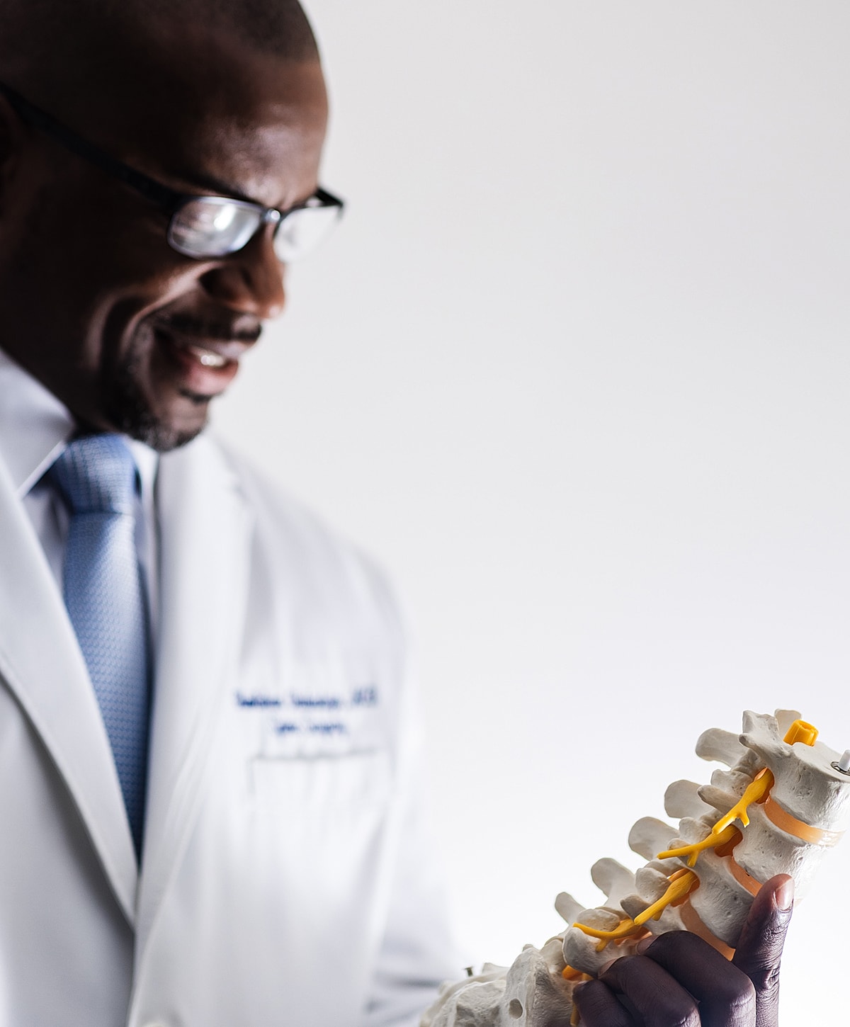 spine surgeon examining a spinal model.
