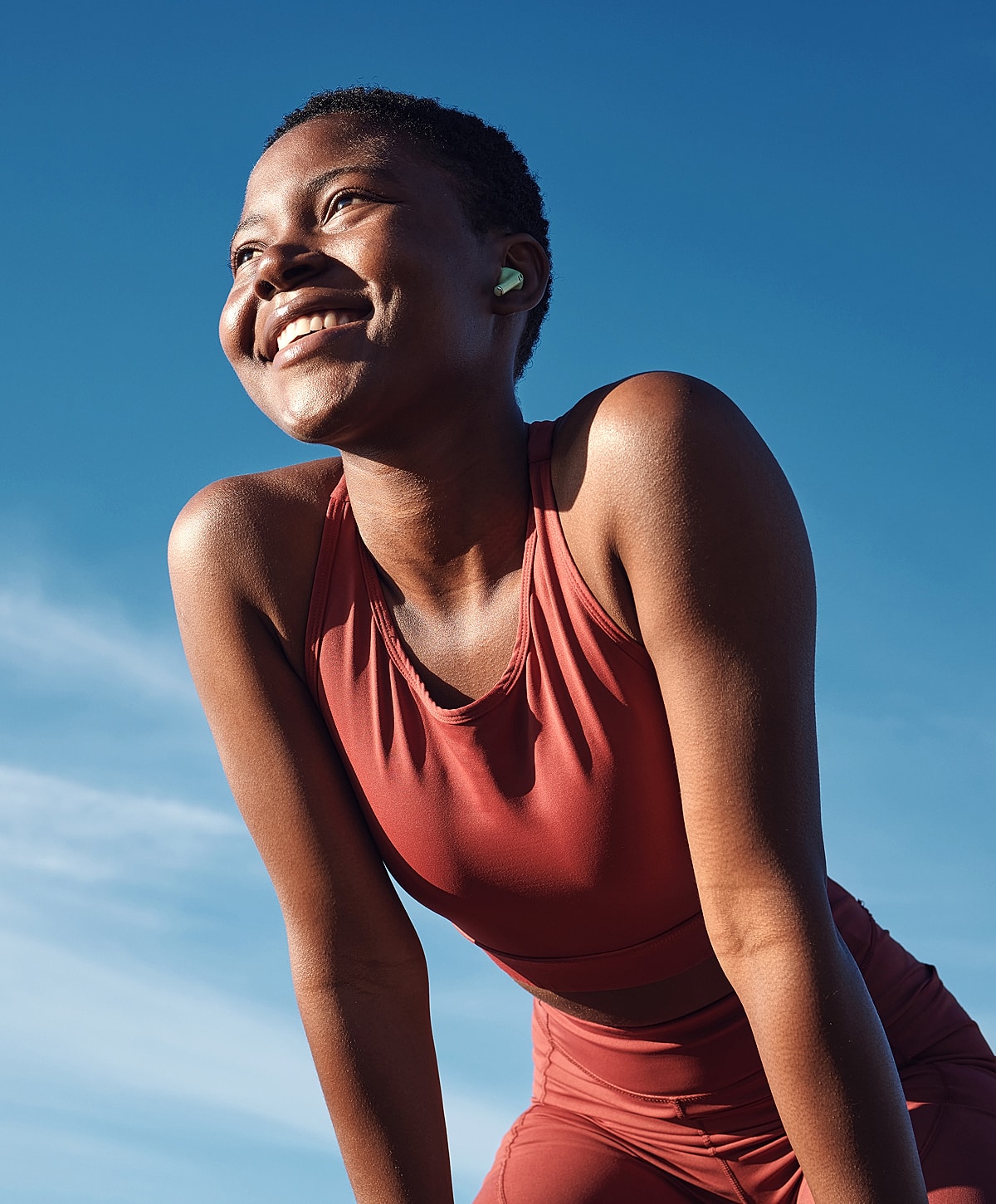 Smiling osteoarthritis patient model enjoying outdoor workout in sunlight.