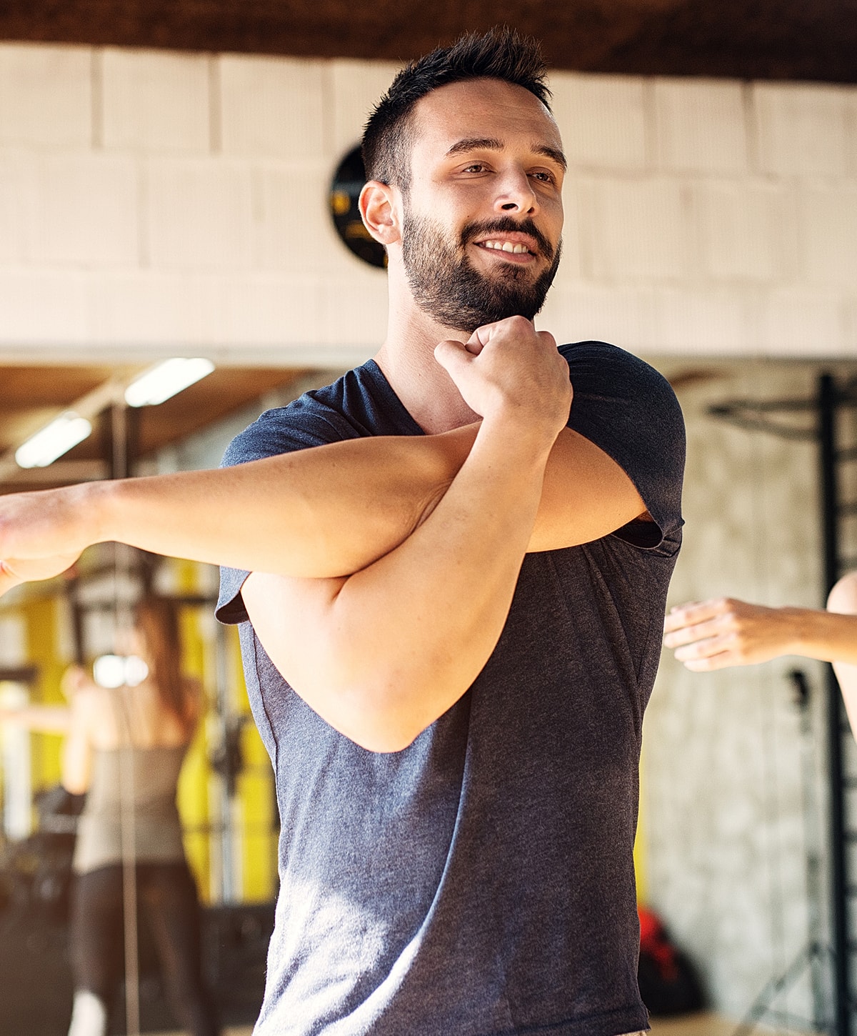 osteoporosis treatment patient model stretching in a gym setting.