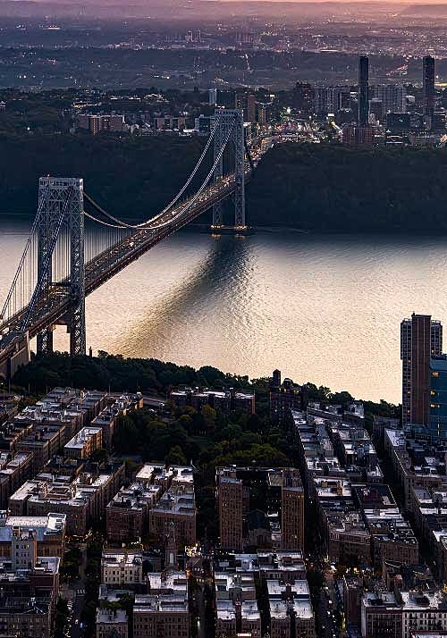 George Washington Bridge at sunset over water.