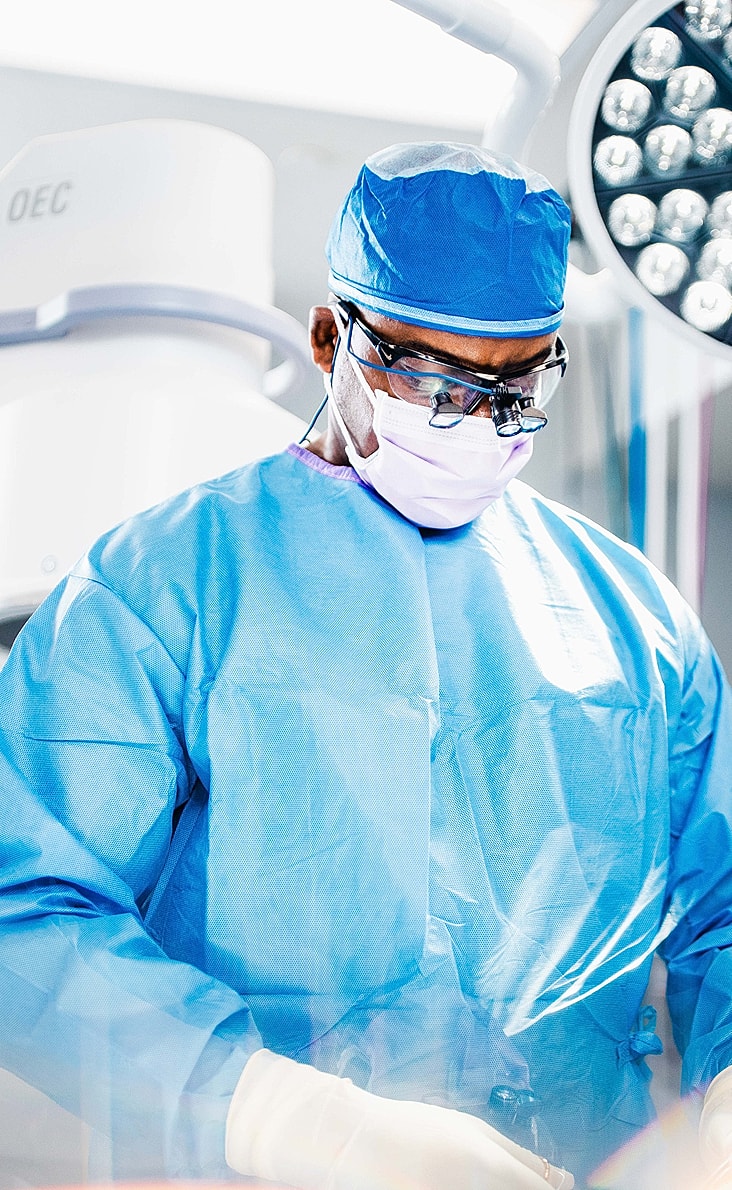 Spine surgeon preparing for operation in sterile environment.
