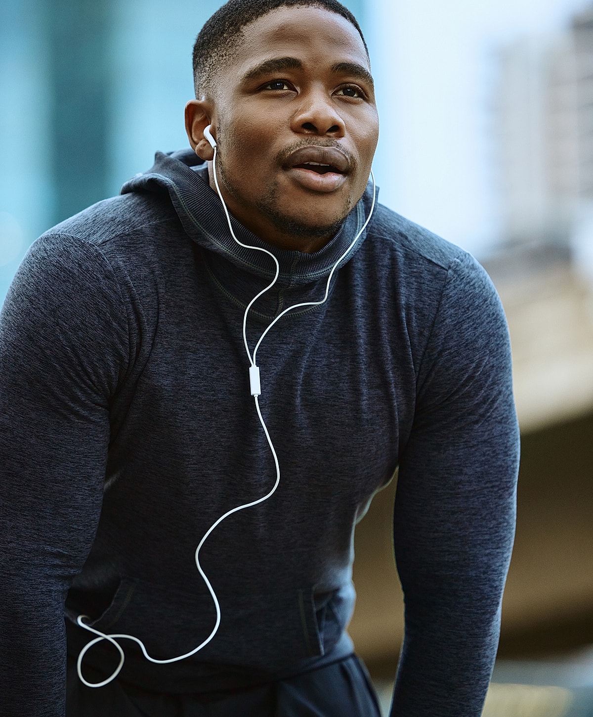 Disc replacement surgery patient model wearing headphones, looking focused outdoors.