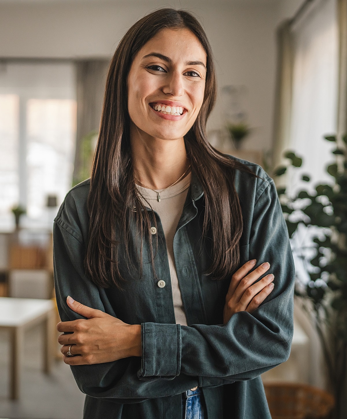 Smiling anterior cervical discectomy patient model standing indoors with crossed arms.
